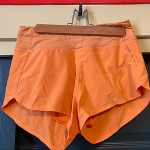 Outdoor Voice orange running shorts with pocket